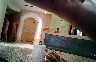 粉红色的床上苗条的黑发女人用自己的双手抚摸着剃光的裂缝